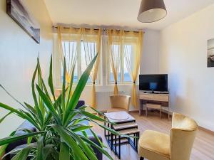 uma sala de estar com um vaso de plantas e uma televisão em Horizons "Vue Mer" em Royan