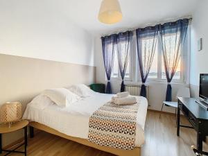 Schlafzimmer mit einem Bett mit blauen Vorhängen und einem Schreibtisch in der Unterkunft Horizons "Vue Mer" in Royan