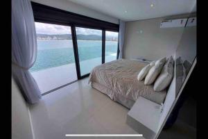 a bedroom with a bed with a view of the ocean at Mansão com vista cinematográfica pro mar! in Guarujá