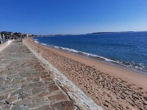 a beach with a retaining wall and the ocean at Cosy Appartement in Cannes