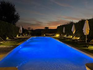 a large blue swimming pool at night with umbrellas at La Bastide in La Colle-sur-Loup