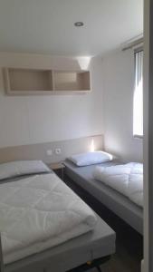 a bedroom with two beds and a window at MOBILHOME EN BORD DE MER sur camping 4 étoiles in Saint-Jean-de-Monts
