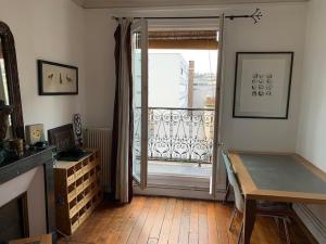 a living room with a door open to a balcony at Stylish Flat with Balcony Facing South in Paris