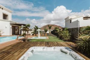 馬西尼古蒂的住宿－Villa Marabú，享有庭院内带热水浴池的房子的景致