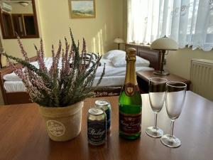 una mesa con dos botellas de champán y dos copas en GLORIETTA Apartments & SPA, en Iwonicz-Zdrój