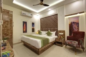 Habitación de hotel con cama y silla en BLESS INN - Near Connaugt Place en Nueva Delhi