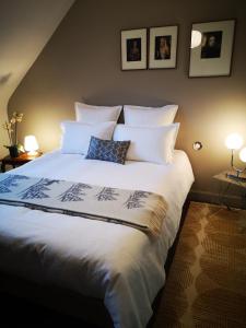 a bedroom with a large bed with white sheets and pillows at Maison et Florescence in Nuits-Saint-Georges