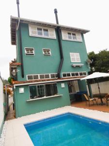 uma casa com uma piscina em frente em Refúgio da Serra em Petrópolis