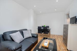 a living room with a black couch and a table at Bermondsey London 3 People Apartment Peaceful in London