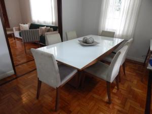 - une table à manger et des chaises blanches dans la chambre dans l'établissement Refúgio da Serra, à Petrópolis