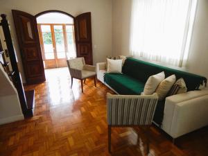 uma sala de estar com um sofá verde e uma cadeira em Refúgio da Serra em Petrópolis