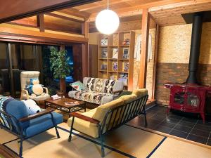 - un salon avec un canapé et un poêle à bois dans l'établissement ゲストハウスでたらめ荘, à Yamakami