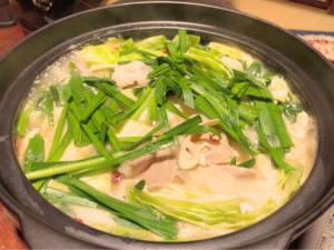 un tazón de sopa con cebolla verde y carne en ゲストハウスでたらめ荘, en Yamakami