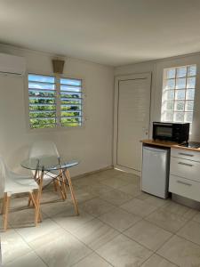 a kitchen with a table and a table and chairs at Tropic Valley Lodge in Vieux-Habitants