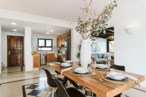 馬西尼古蒂的住宿－Villa Marabú，厨房以及带木桌和椅子的用餐室。