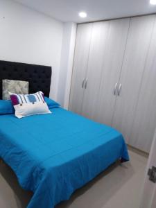 a bedroom with a blue bed and white cabinets at Apartamento 3 hab 2 baños in Santa Rosa de Cabal
