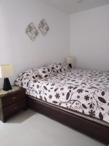 a bedroom with a bed with a black and white comforter at Apartamento 3 hab 2 baños in Santa Rosa de Cabal