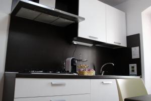 una cucina con armadietti bianchi e una parete nera di Room and Breakfast Luciana Sant'Elia a Pianisi a SantʼElia a Pianisi