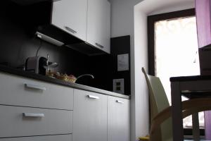 una cucina con armadietti bianchi e una finestra di Room and Breakfast Luciana Sant'Elia a Pianisi a SantʼElia a Pianisi