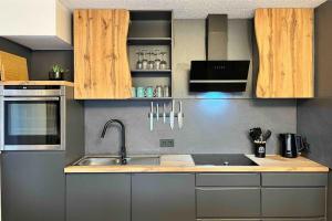 a kitchen with wooden cabinets and a sink at Auszeit am Berg in Lenzkirch