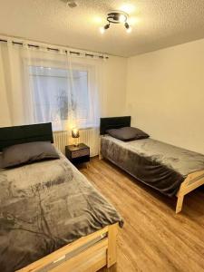 a bedroom with two twin beds and a window at Auszeit am Berg in Lenzkirch