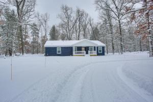 una casa azul en la nieve en un camino nevado en Wellston Home with Private Hot Tub and Fire Pit! en Irons