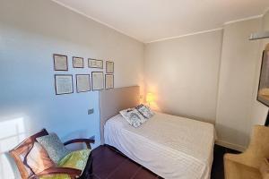 een kleine slaapkamer met een bed en een stoel bij HENRI CAMILLE -POMPADOUR - Studio city center - 8 min Palais in Cannes