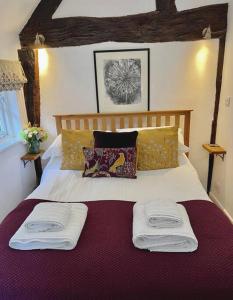 a bedroom with a bed with two towels on it at Hideaway Cottage in Ludlow
