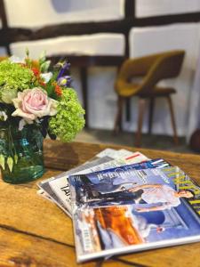 a table with a magazine and a vase of flowers at Hideaway Cottage in Ludlow