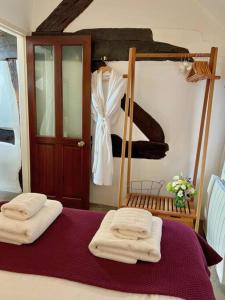 a bedroom with a bed with towels on it at Hideaway Cottage in Ludlow