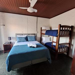 a bedroom with a bed and two bunk beds at Pousada Trilha da Serra in Morretes