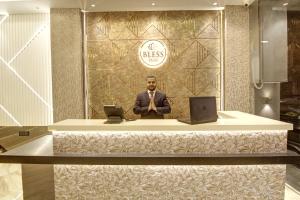 a man standing at a desk with two laptops at BLESS INN - Near Connaugt Place in New Delhi