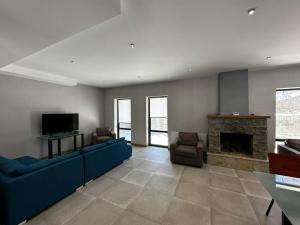 a living room with blue couches and a fireplace at BANOVANI Bakuriani in Bakuriani