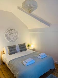 a bedroom with a bed with two towels on it at Beautiful sea view, tranquil loft apartment in Lytham St Annes