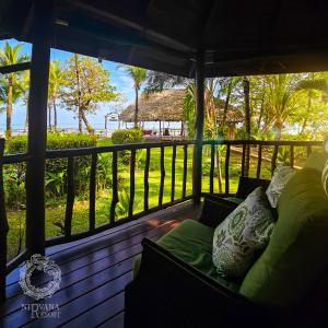a porch with a couch and a view of the ocean at Nirvana Resort in Lívingston