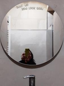 une personne prenant une photo dans un miroir de salle de bains dans l'établissement GiuGi Home, à Matera