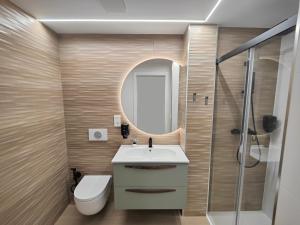 a bathroom with a sink and a toilet and a mirror at ELEGANCIA Y MODERNIDAD EN PLENO CENTRO in Oviedo