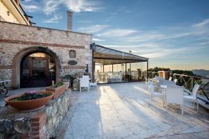 a patio with white chairs and a brick building at The Life in Marcellina