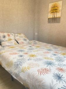 - un lit avec une couette colorée dans l'établissement super 3P appart proche de paris, à Ivry-sur-Seine