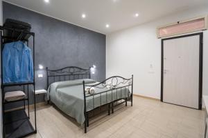 - une chambre avec un lit noir et un placard dans l'établissement Saverio's apartment, à Tropea