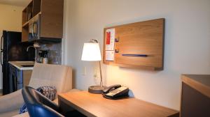 een bureau met een telefoon en een lamp erop bij Candlewood Suites - Peoria at Grand Prairie, an IHG Hotel in Peoria