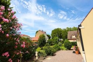 een uitzicht op een tuin met bloemen en huizen bij F3 80 m2 Longére plain pied au centre auxonne. in Auxonne
