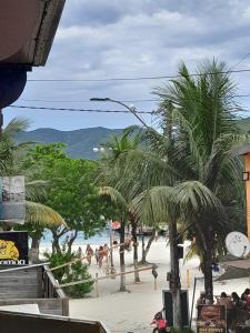 una spiaggia con palme e persone sulla spiaggia di Janelas para o mar ad Arraial do Cabo