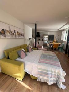 una camera da letto con un letto grande e un divano giallo di Terraza Bolingas a Comillas