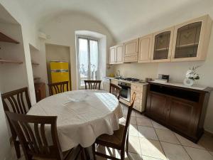 a kitchen with a table and chairs in a kitchen at [2 passi dal mare di Alassio] Ampio trilocale in Alassio
