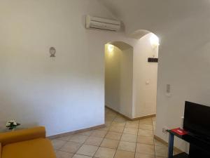 ein Wohnzimmer mit einem Sofa und einer weißen Wand in der Unterkunft [2 passi dal mare di Alassio] Ampio trilocale in Alassio