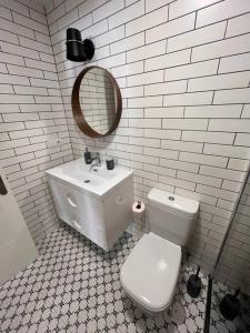 un bagno con un water, un lavandino e uno specchio di Terraza Bolingas a Comillas Altre 23 foto