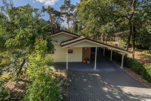 a house with a driveway in front of it at Huisje Elfde Wijk in Rheezerveen