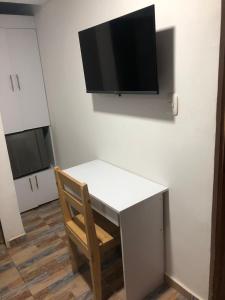 a desk with a chair and a tv on a wall at Mendoza Jeps Barranquilla in Barranquilla