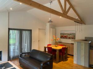 ein Wohnzimmer mit einem Tisch und einem Esszimmer in der Unterkunft Huisje Elfde Wijk in Rheezerveen